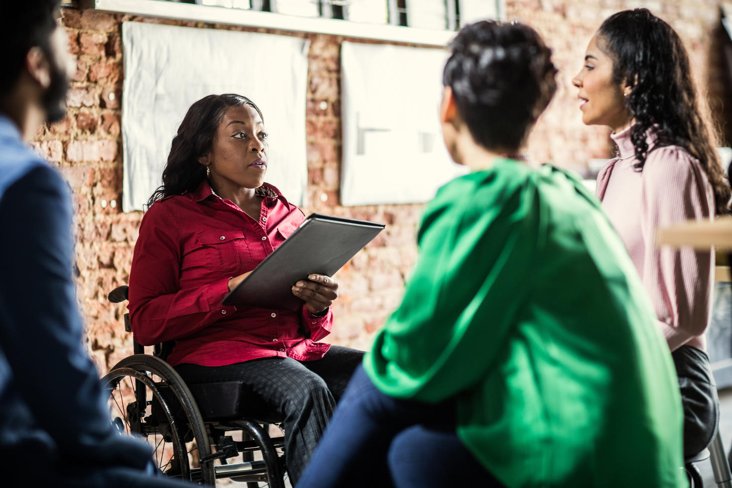 Employees having ground conversation sitting down in circle. 
