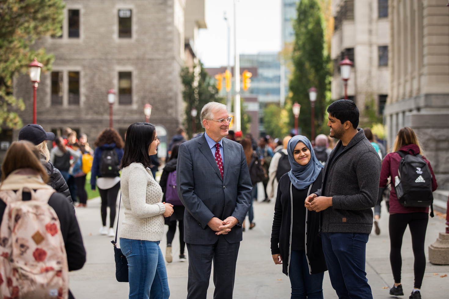 uOttawa President, Jacques Fremont, in conversation with students in front of Tabaret Hall.