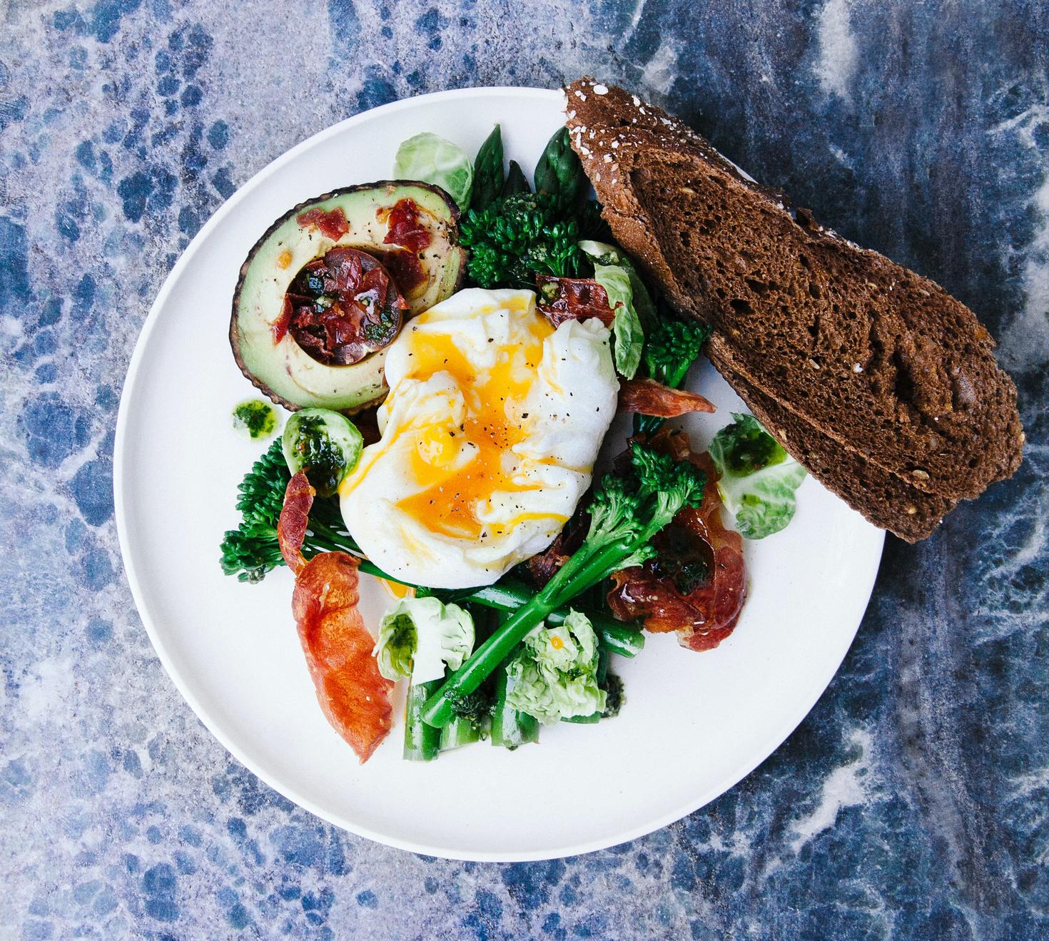 Breakfast plate with veggies, eggs and bread.