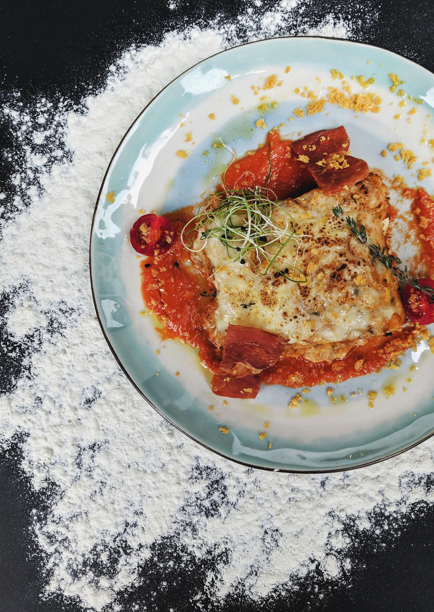 Fancy plated food with flour on table creating a design under plate.