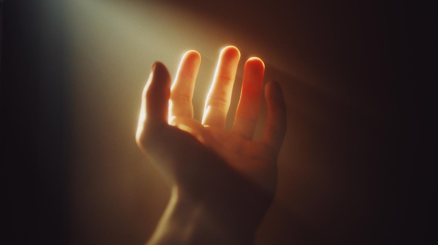 hand reaching through light stream