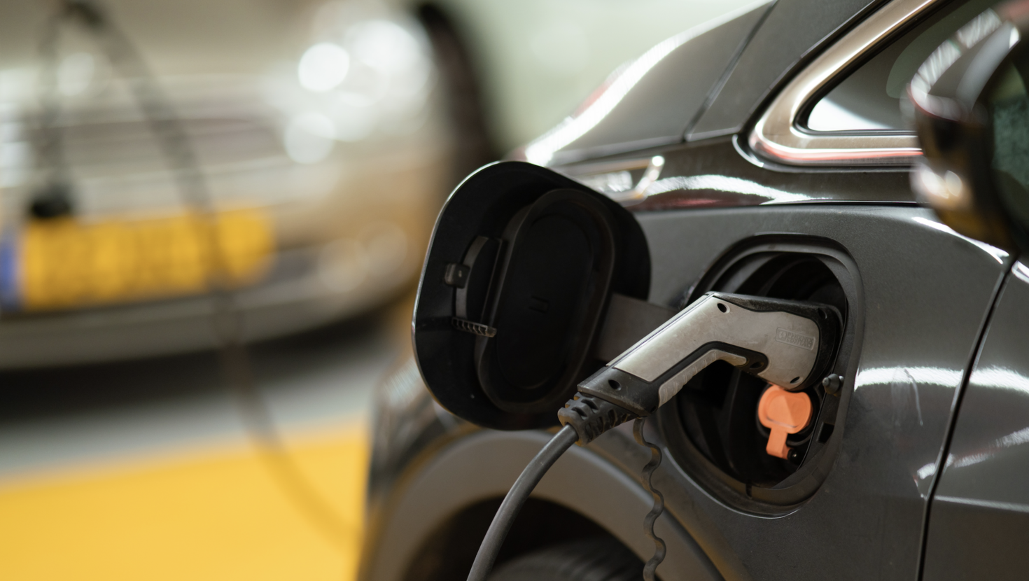 Electric car plugged in in underground parking.
