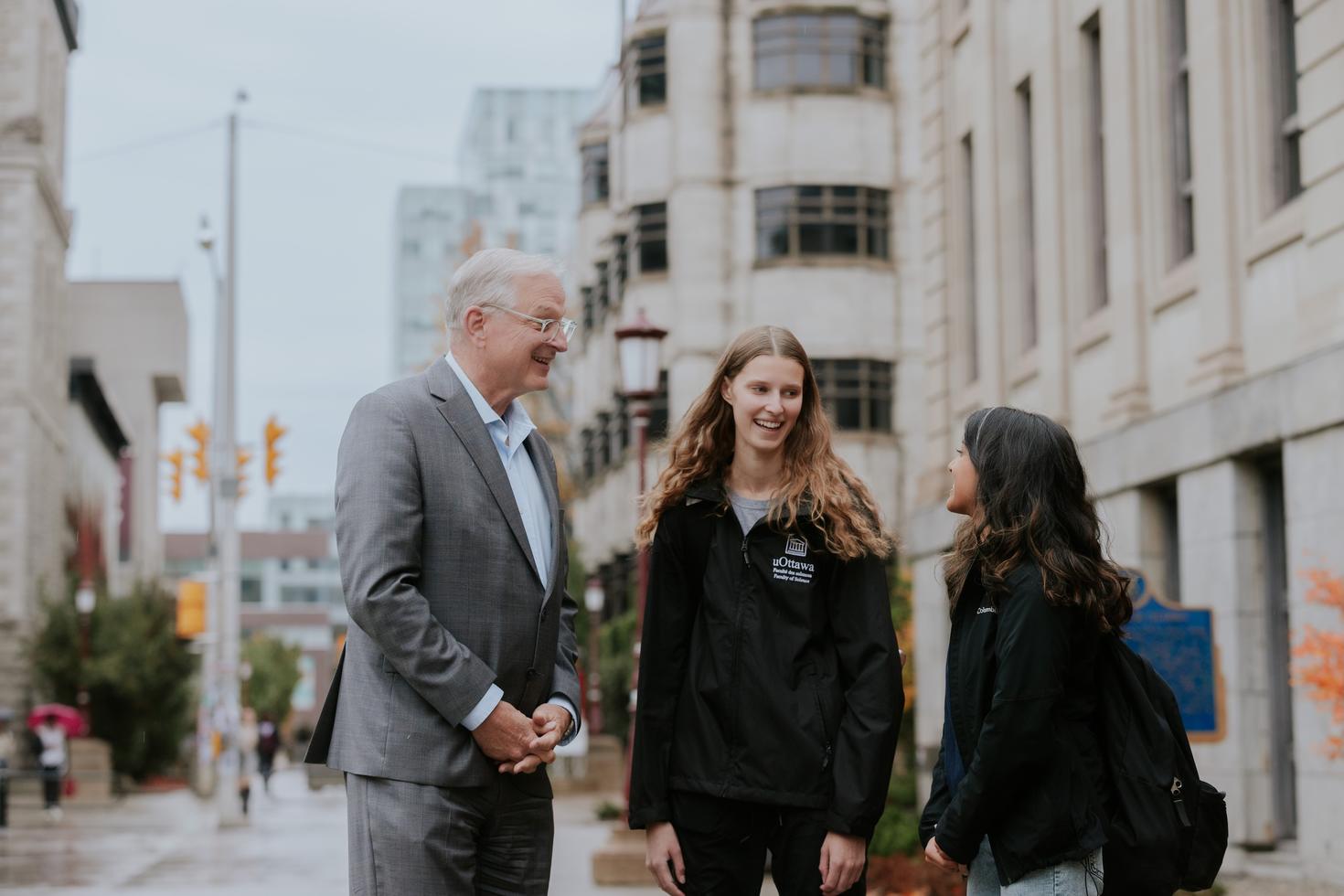 Jacques Frémont speaking with members of the uOttawa community outside.