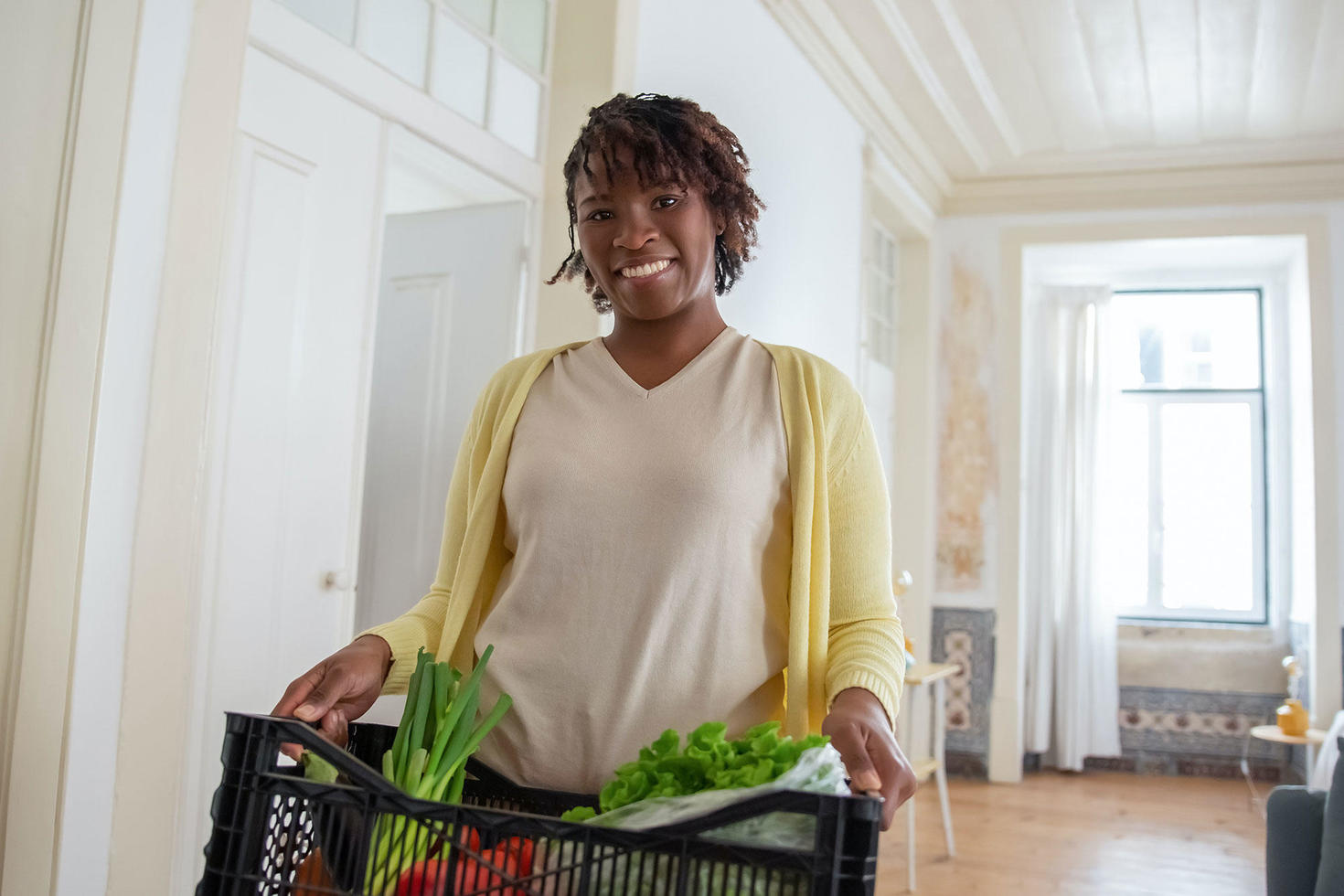 person carrying box of vegetables