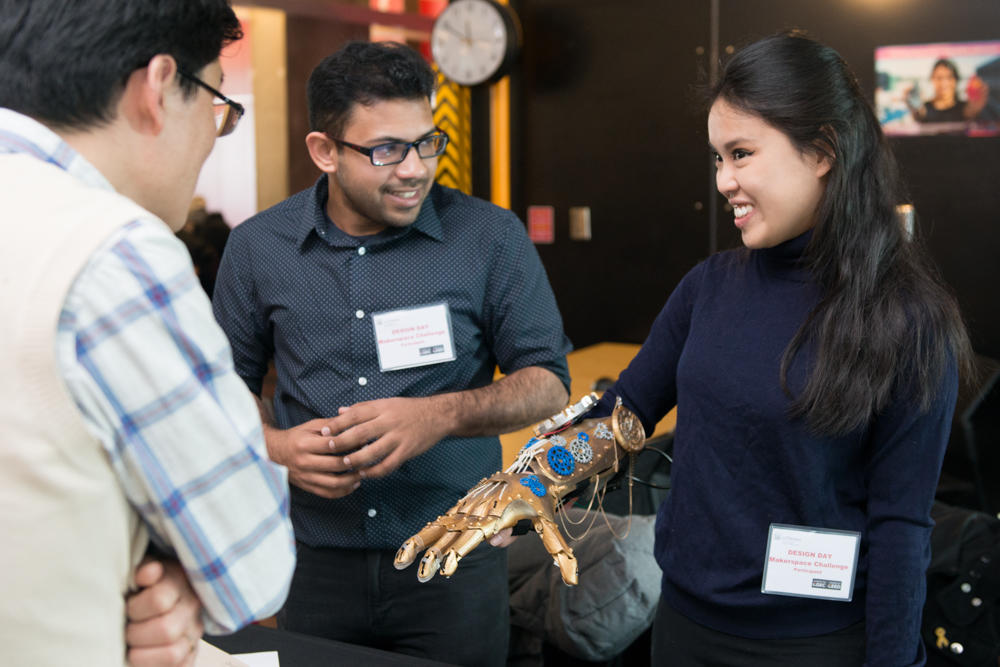 Female student presents robotic hand.