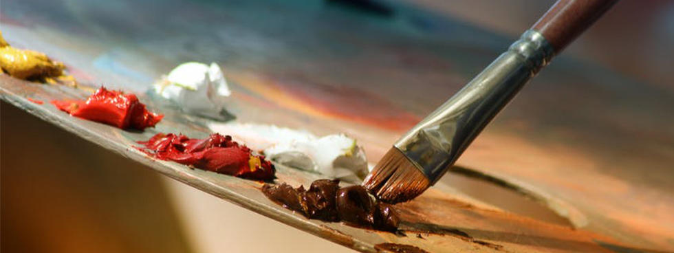 Image showing an artist's palette with globs of paint in yellow, orange, red and brown and a paint brish