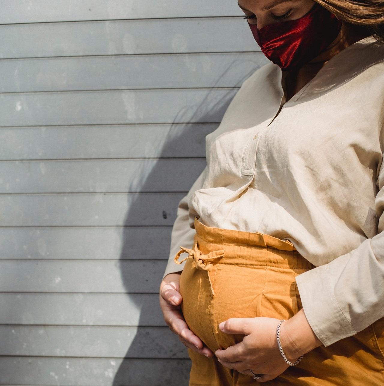 Pregnant individual wearing mask