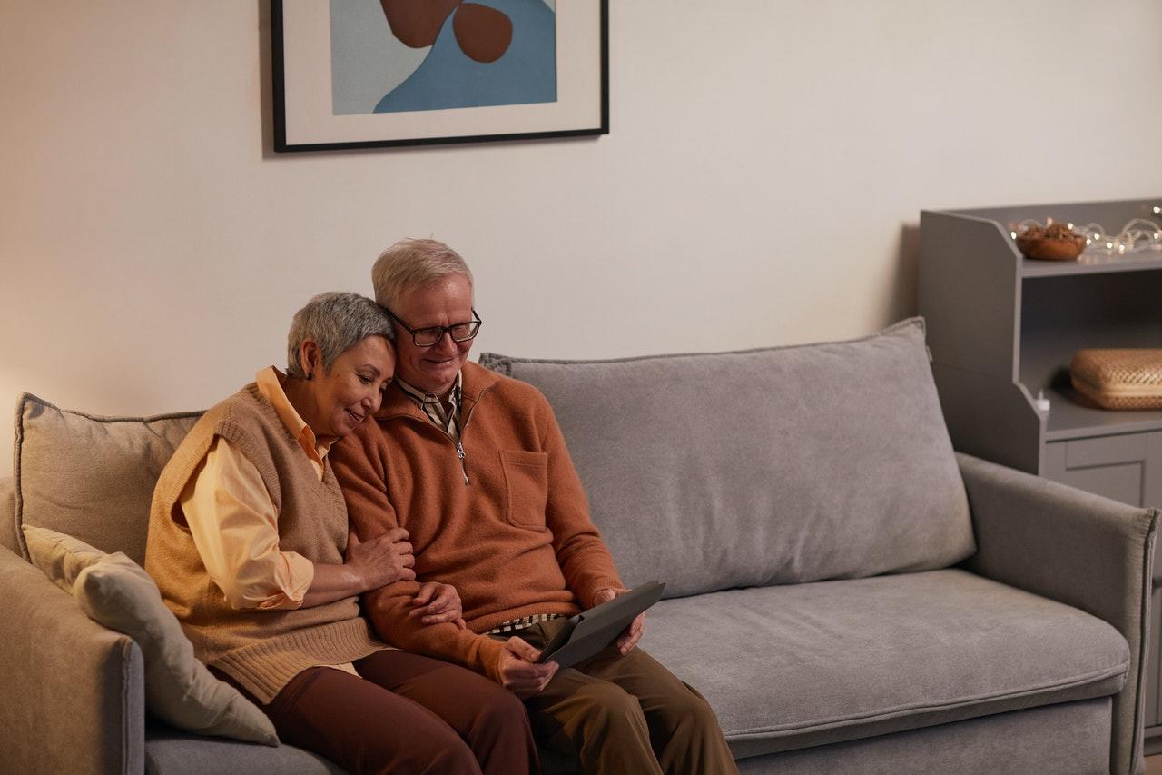 Older couple on couch looking at tablet together