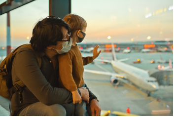 Père et fils regardant des avions décoller à l'intérieur de l'aéroport.