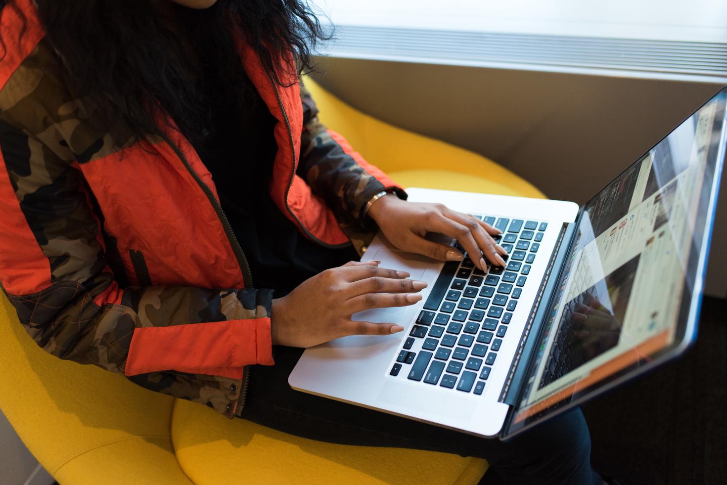 person sits with laptop on lab