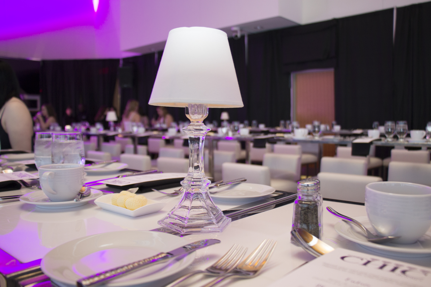 Espace événementiel en soirée avec un éclairage violet.