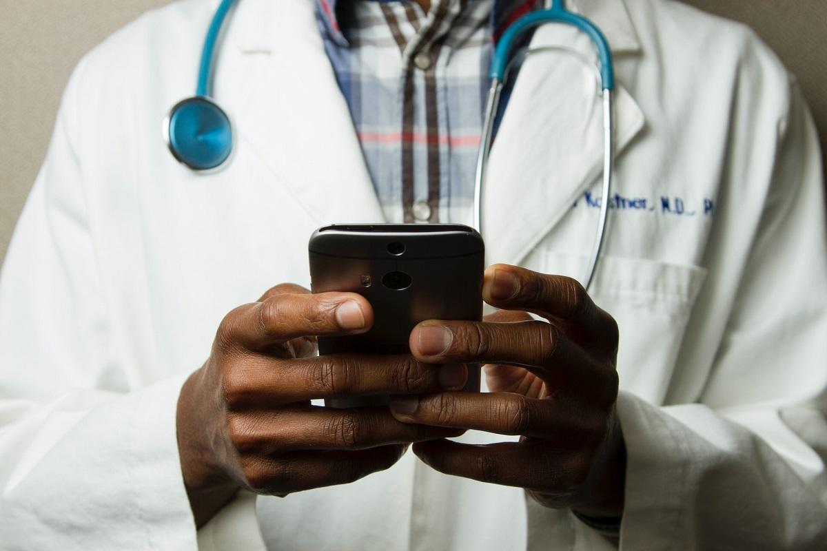 Gros plan des mains d'un médecin utilisant un smartphone