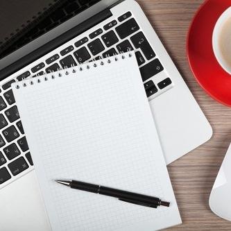 un bloc-note et un crayon sur un ordinateur portable