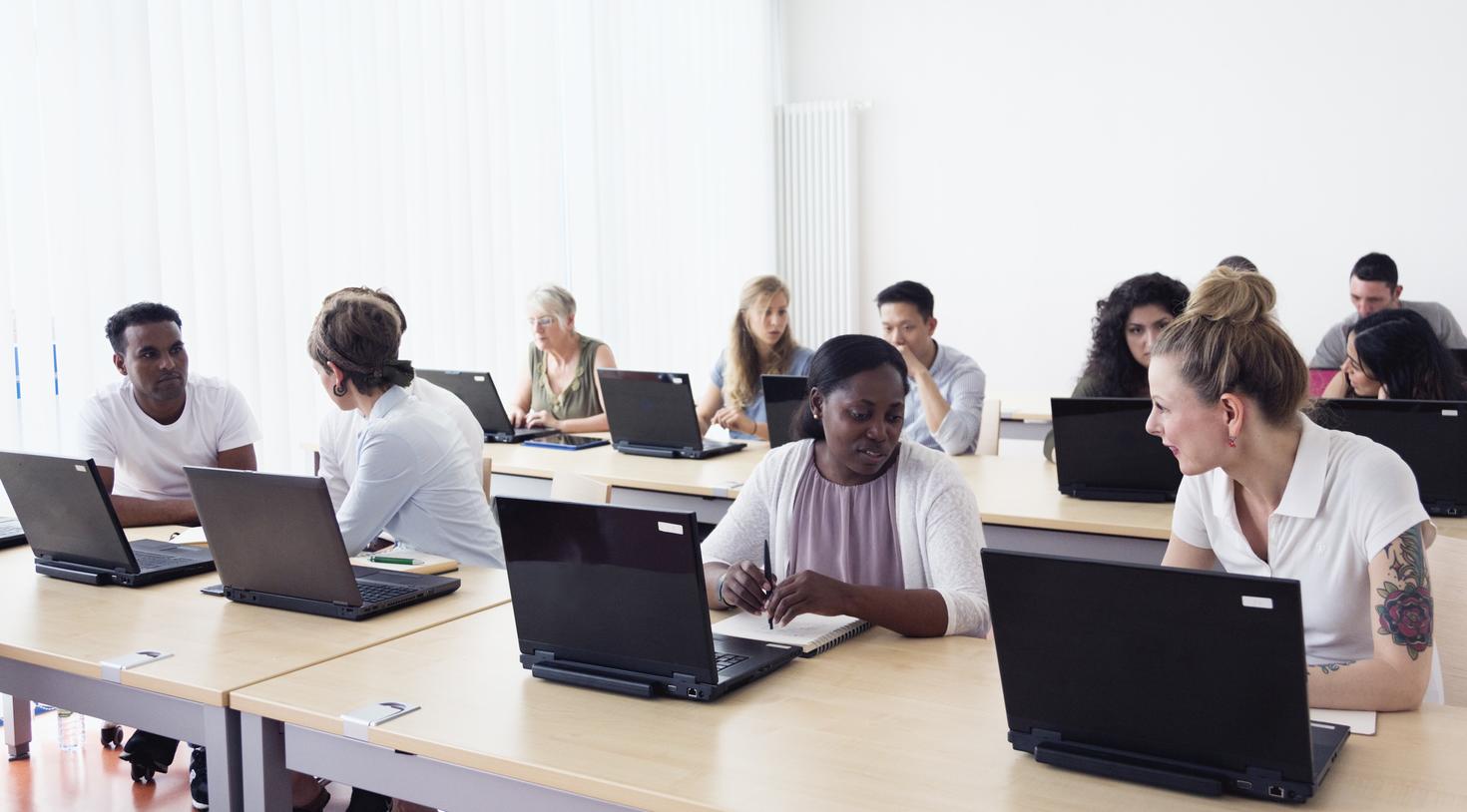 plusieurs personnes assisent devant leur ordinateur.