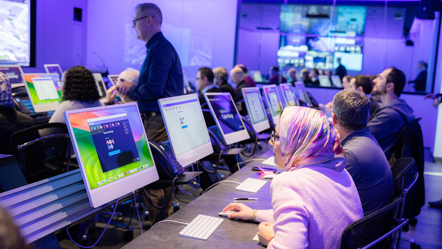Groupe de personnes assisent dans une salle informatique