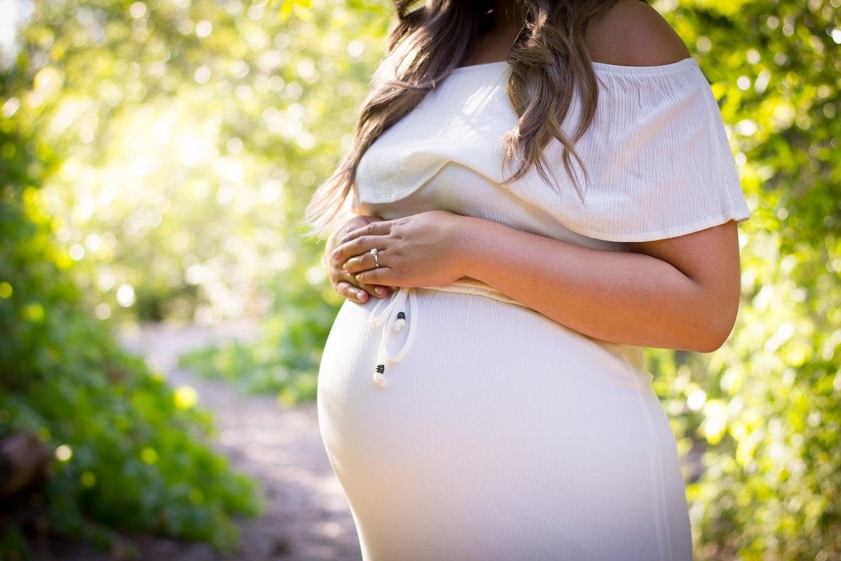 Femme enceinte avec les mains sur le ventre