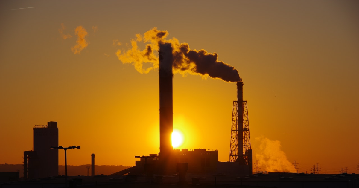 Fumée qui sort d'une cheminée, avec le soleil derrière