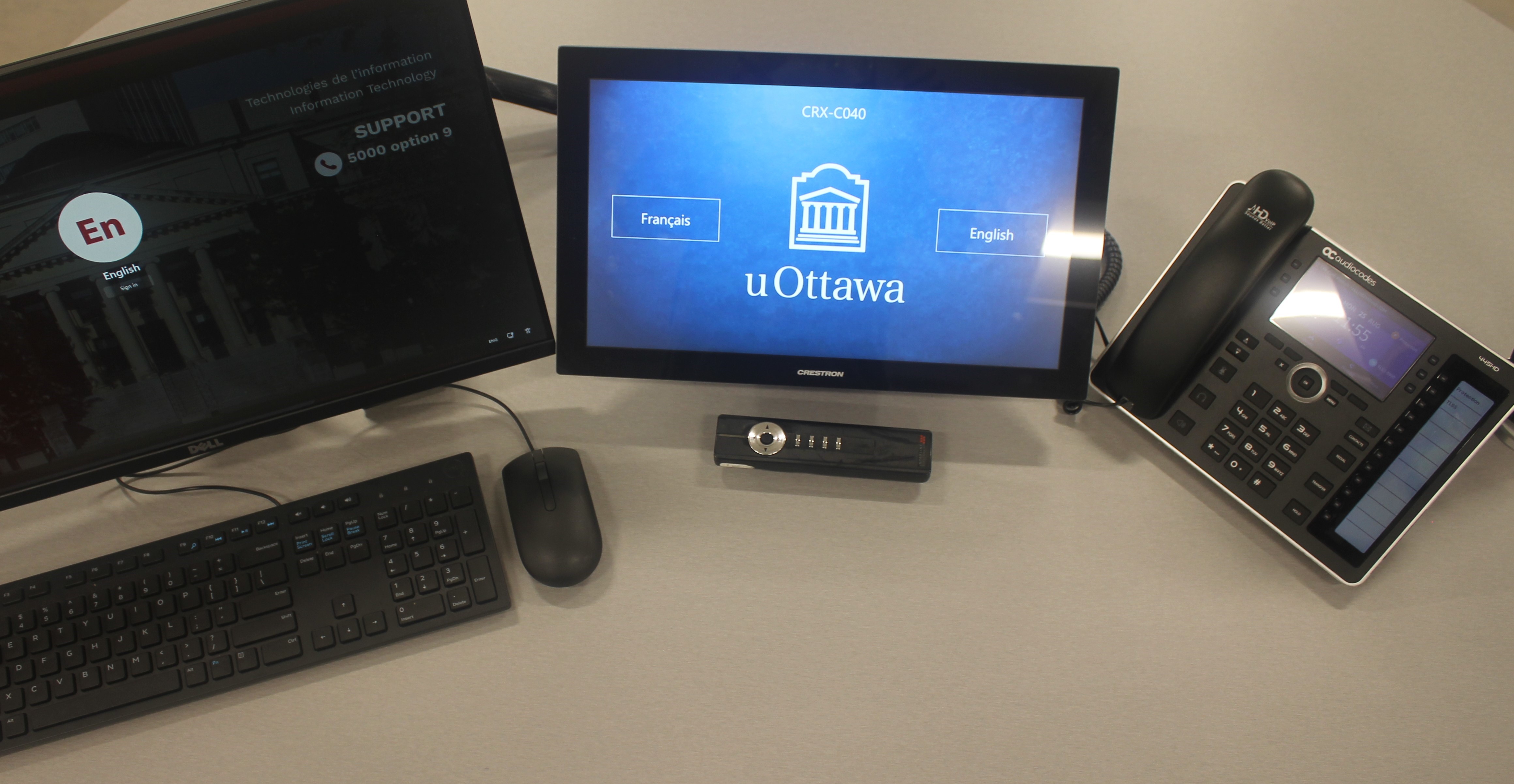 A workspace with a laptop displaying a support technician’s interface, a wireless mouse and a remote control