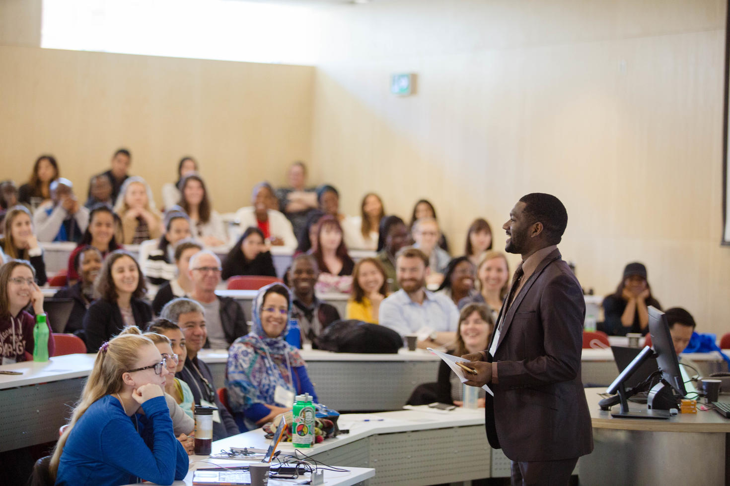 classroom full of student with a professor in front of the crowd