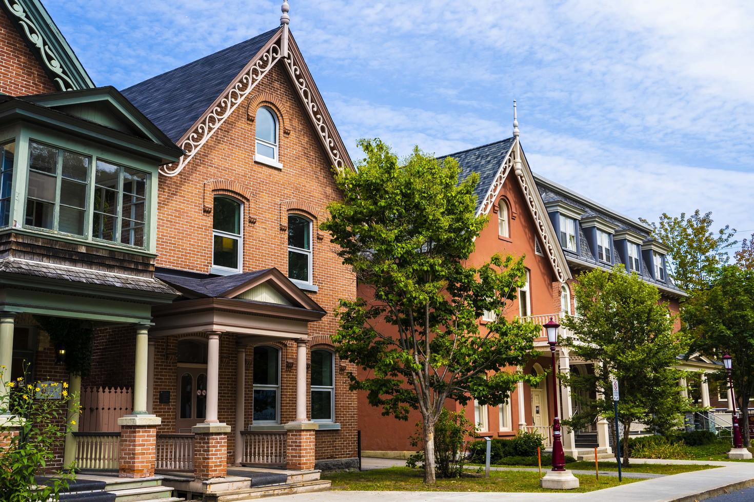 Image shows a row of brick houses, among them the new Indigenous Resource Centre on campus.