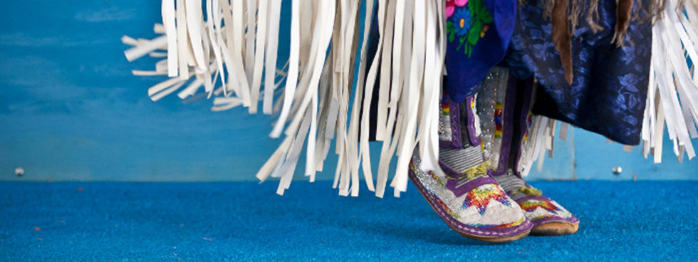 A closeup of a traditional dancer, regalia and moccasins.
