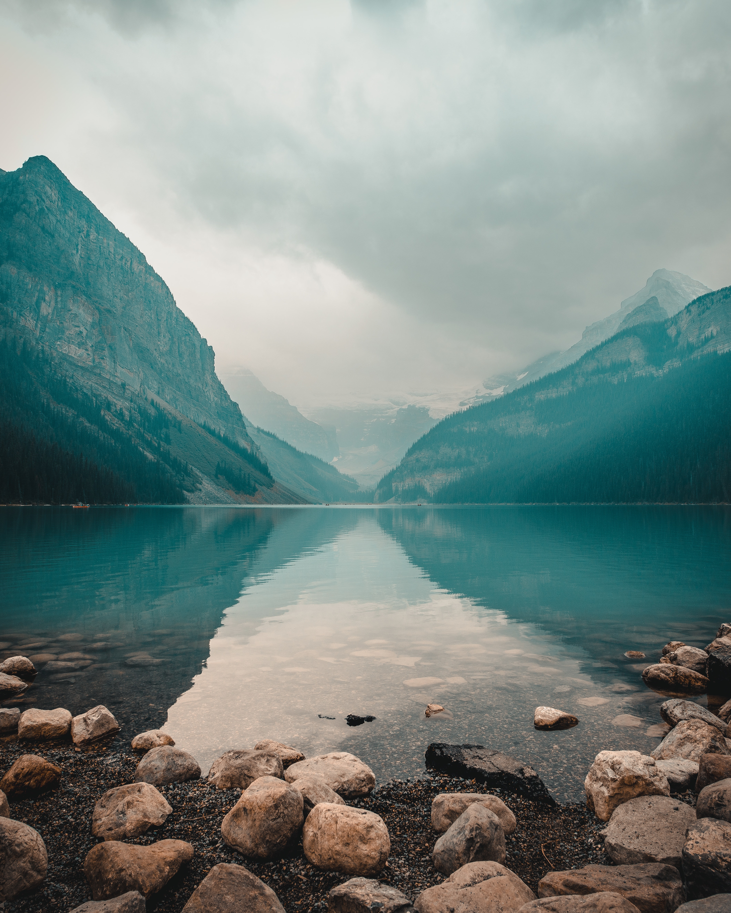 Lake and mountain range in background with rocks in foreground.