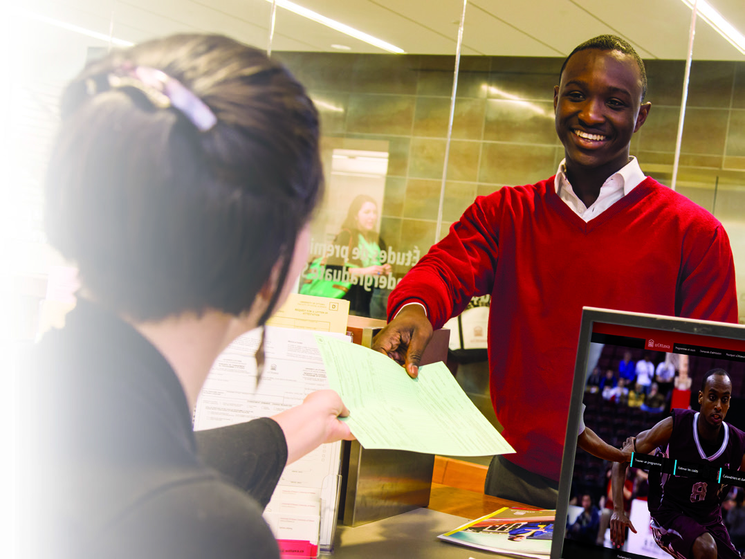 Student handing paper to receptionist. 