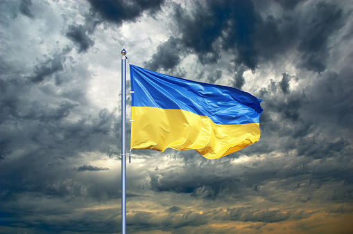 Ukraine flag fluttering against gloomy sky