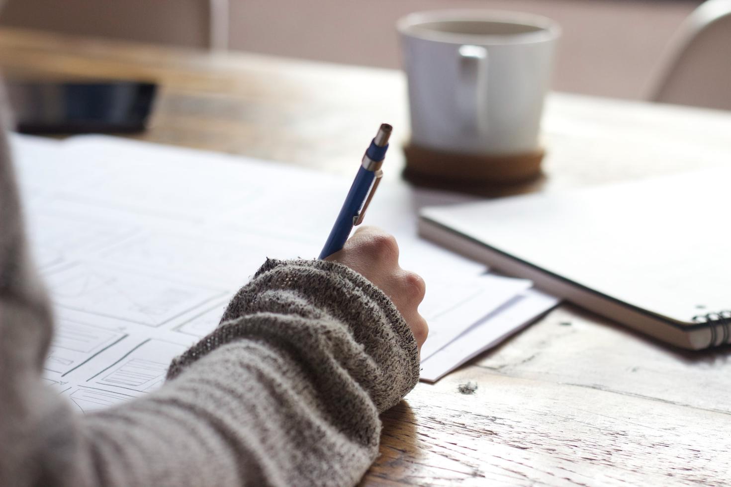 a hand writing in a notebook