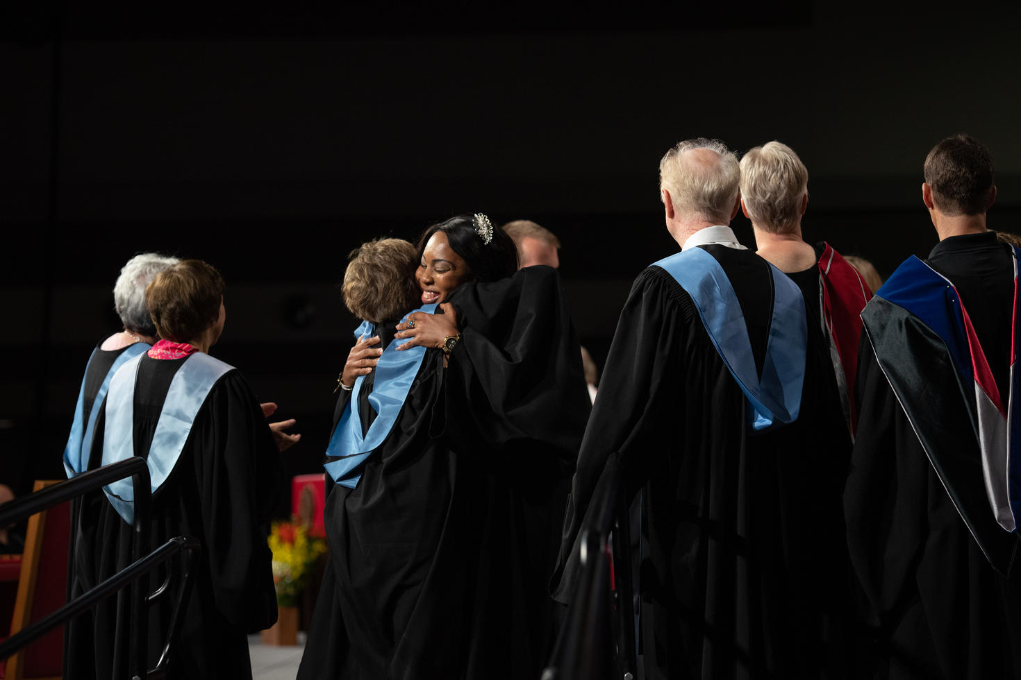 Graduate and professor hugging
