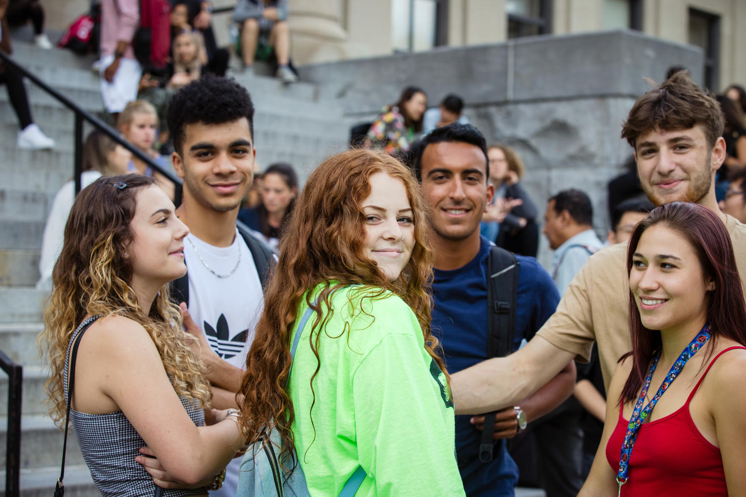 Group of students on campus with girl looking back to camera