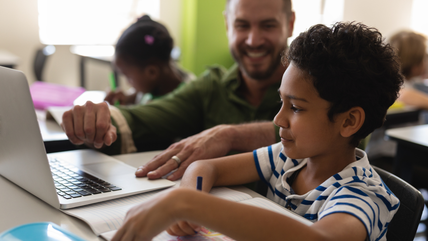 A teacher and his student on a laptop