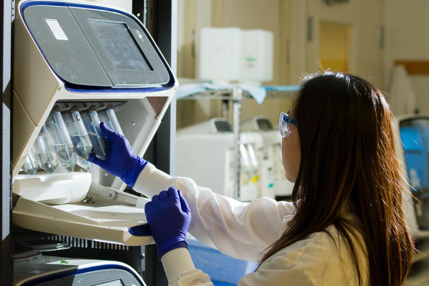 Female scientist in lab looking at test tubes