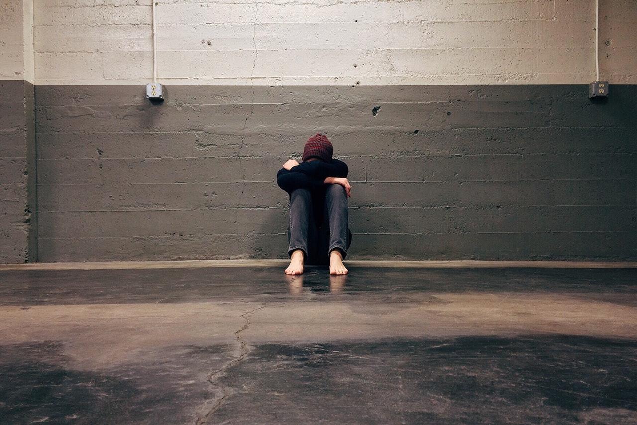 Adolescent with head buried in arms