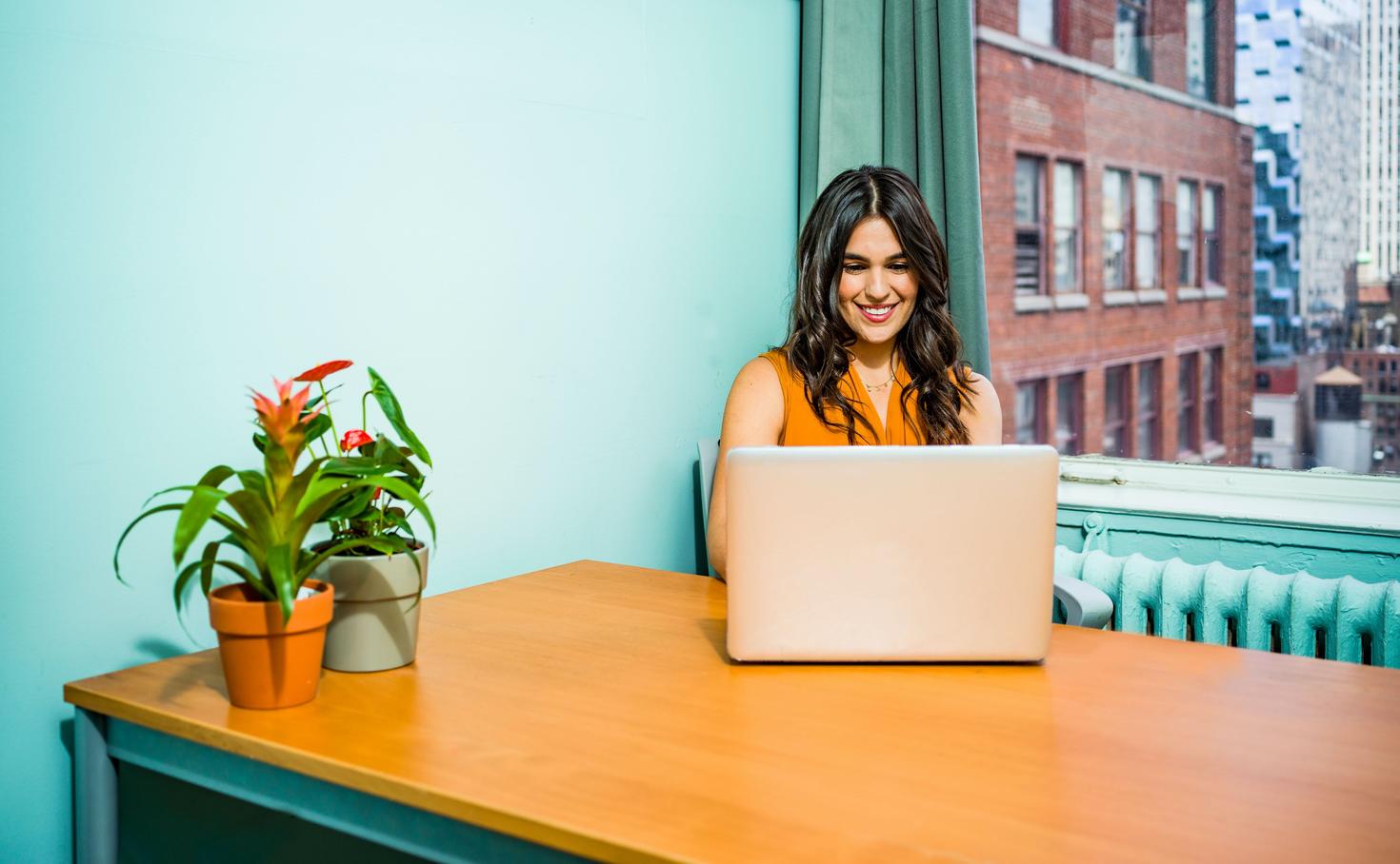  Woman sitting at desk while working on laptop
