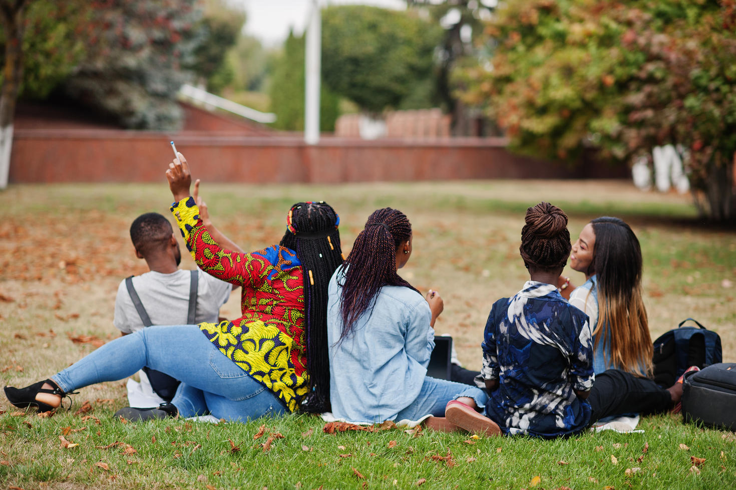 Five college students sitting on grass