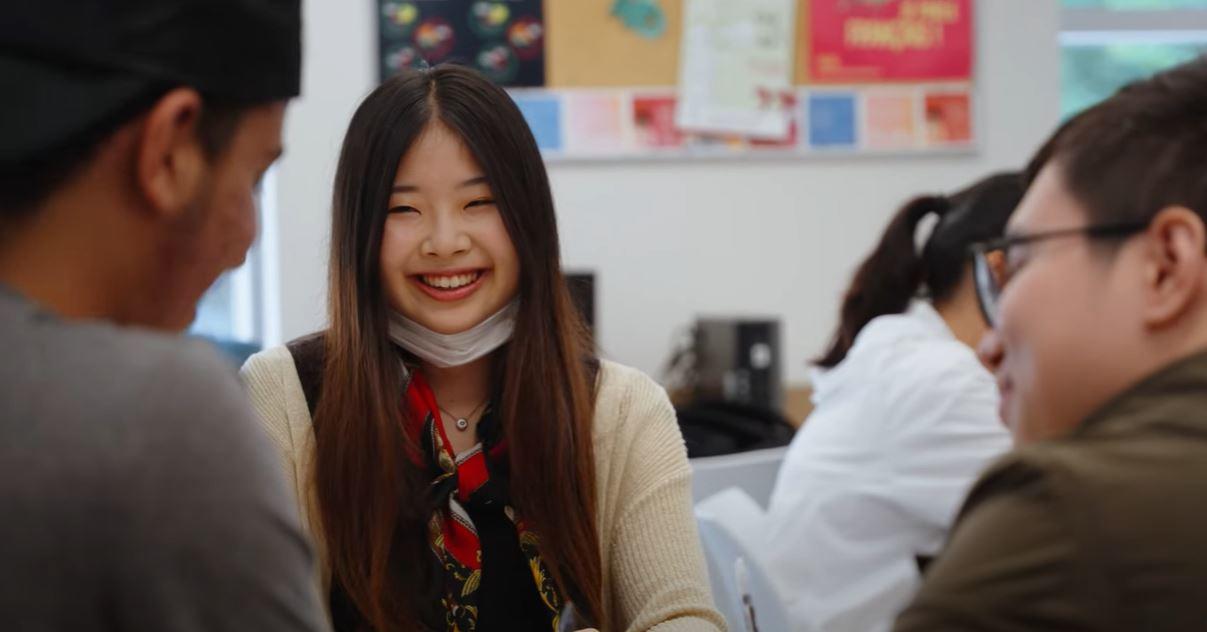 Student smiling - working with other students