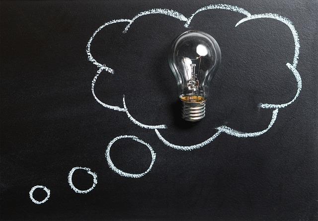 Lightbulb surrounded by chalk drawing of a thought bubble.