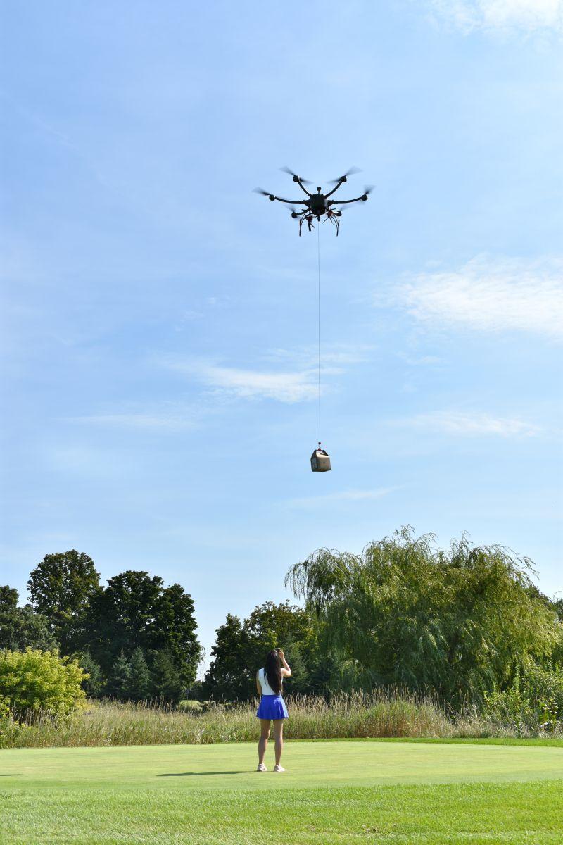A Kirality drone delivers a parcel on a golf course.