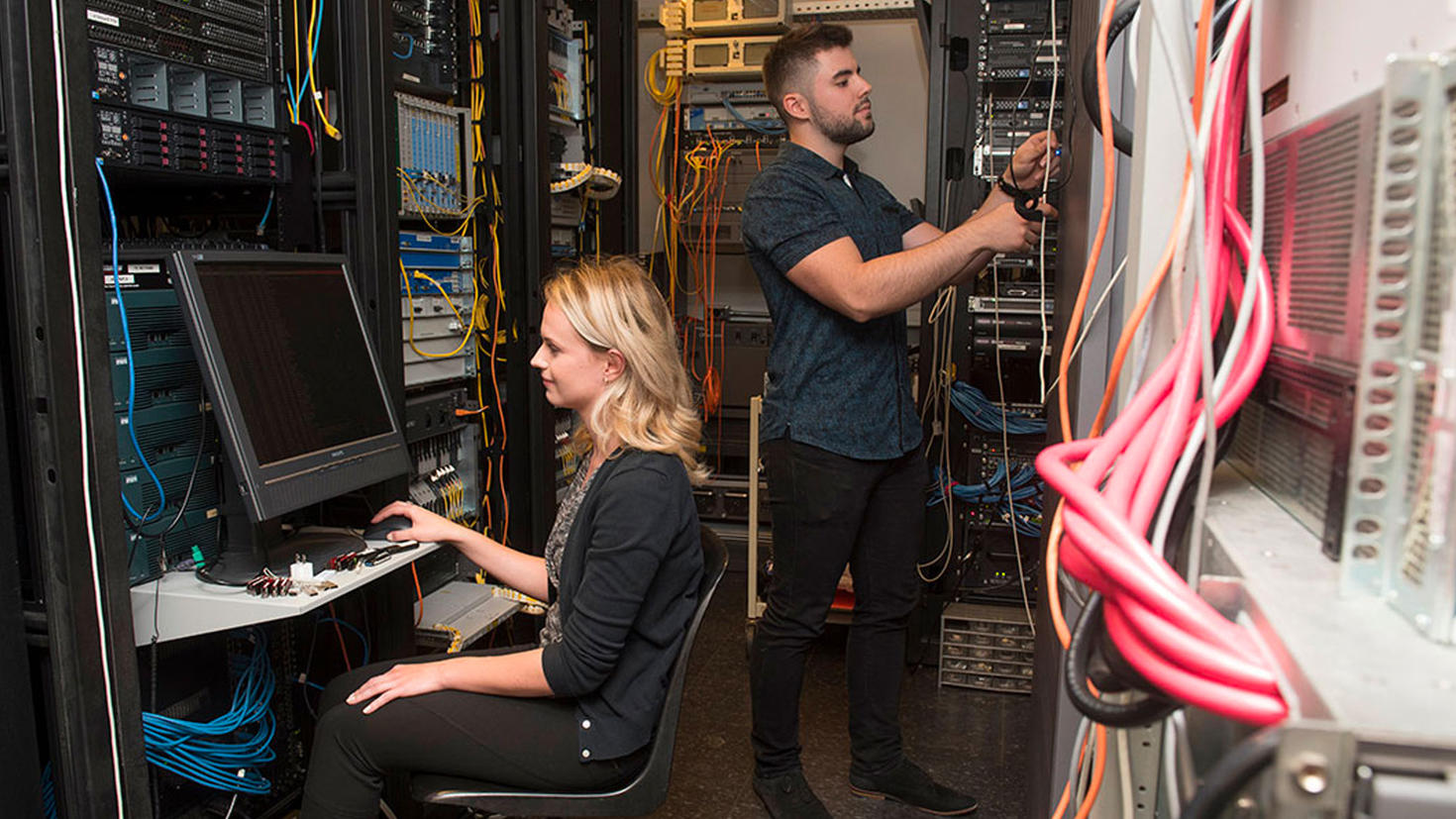 Man and woman working in a server room.