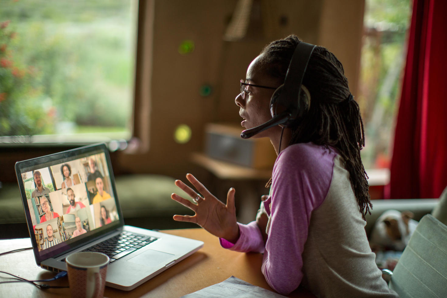 Person speaking on headset in video conference. 