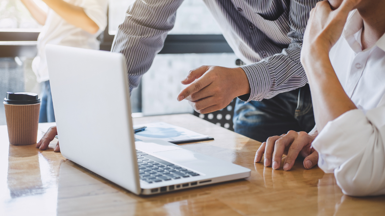 a person pointing on a laptop