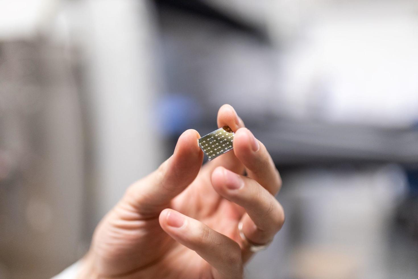 Professor Lessard holding a carbon-based microchip