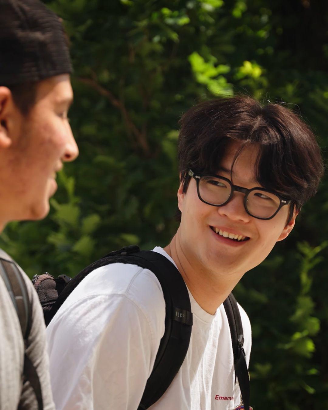 Two students smiling and talking to each other.