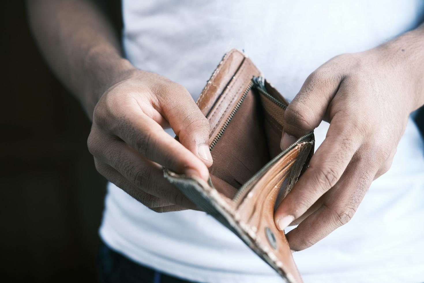 Man opening wallet to reveal it's empty