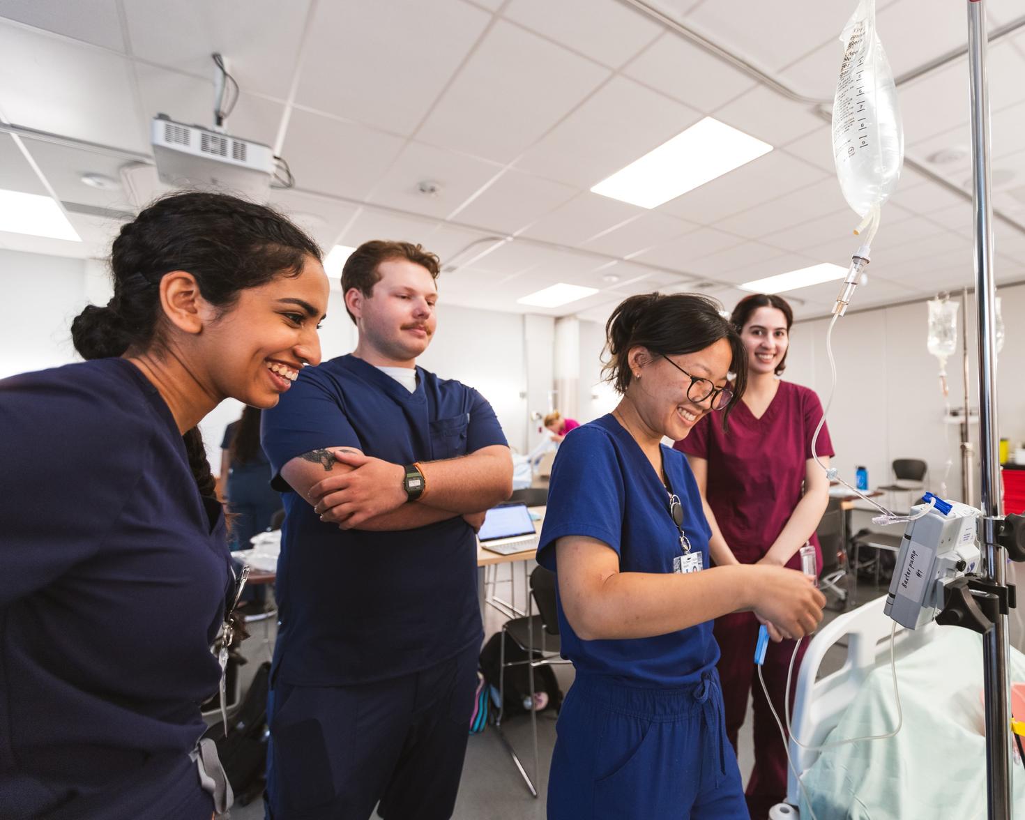4 med school students standing next to each other, smiling.