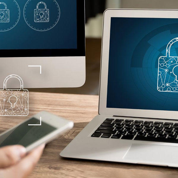 Mobile device in hand and laptop screen displaying a padlock