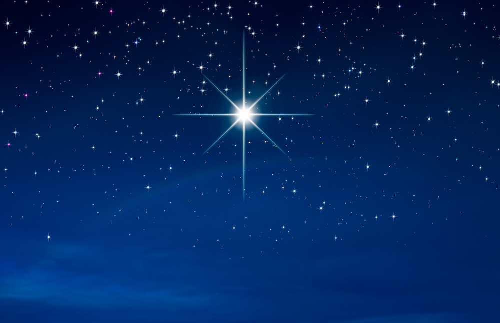 A bright star shines prominently in a clear night sky filled with smaller stars above a faint blue horizon.