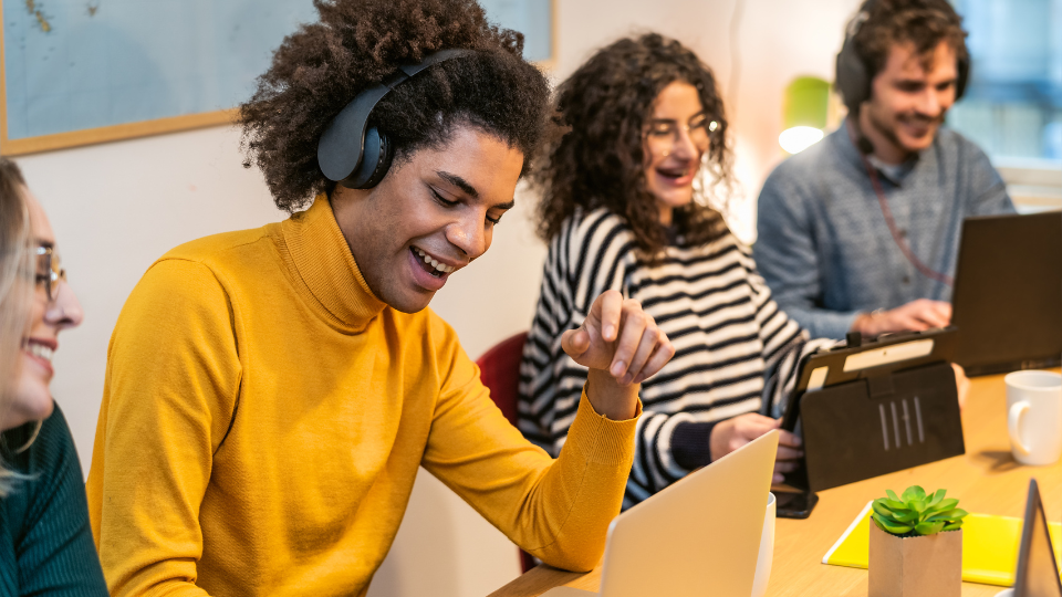 Group of students in front of computers smiling together