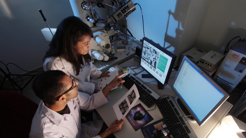 2 researchers discussing in front of a computer 